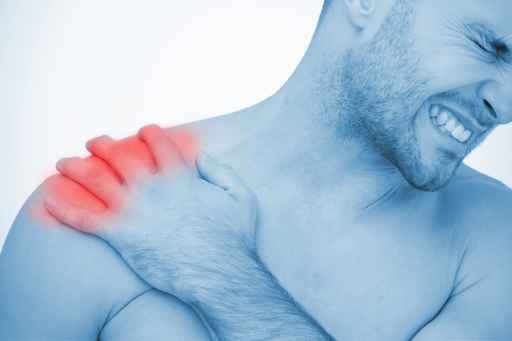 Man wincing in pain at shoulder pain